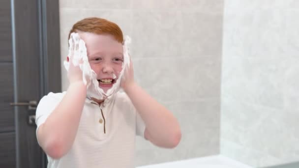 El chico se untó las mejillas con espuma de afeitar — Vídeos de Stock