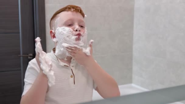 El chico se untó las mejillas con espuma de afeitar — Vídeos de Stock