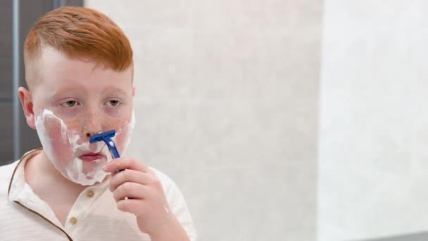 Kleiner Junge rasiert sich sein Gesicht im Badezimmer — Stockvideo