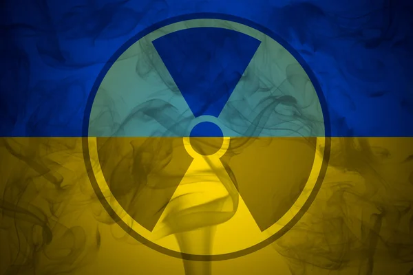 Tanda radiasi di latar belakang bendera Ukraina. Risiko perang nuklir dan polusi radiasi Stok Gambar