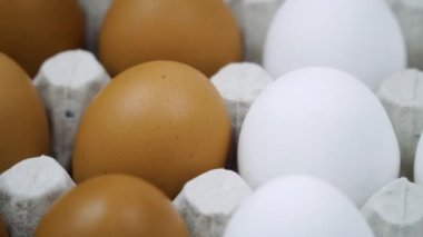 Bir sürü kahverengi ve beyaz yumurta dönüyor. Sırayla taze çiğ tavuk yumurtası.