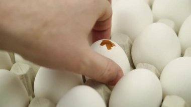 El, kırık yumurtayı platformdaki tüm altın yumurtaya çeviriyor. Yakın çekim. Bir sürü çiğ tavuk yumurtası.