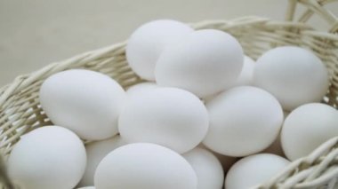 Dönüşümlü bir sepette çiğ yumurta. Sırayla beyaz tavuk yumurtaları.