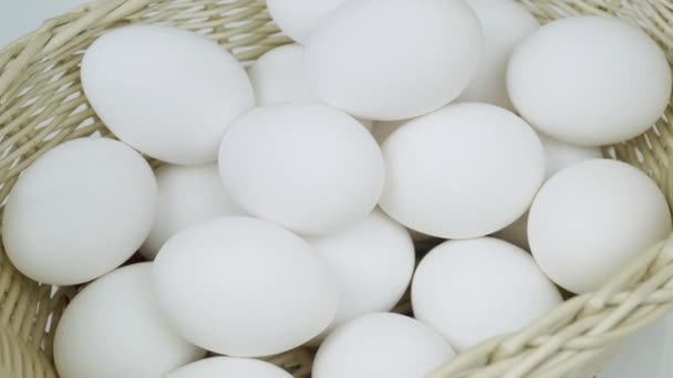 Huevos crudos en una cesta giratoria. Huevos de pollo blanco a su vez vista superior — Vídeos de Stock