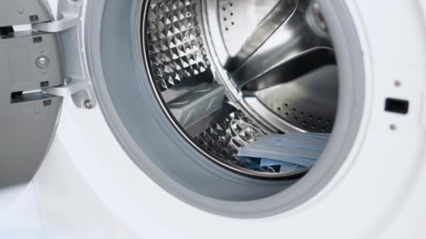 The male hand puts medical masks in washing machine. Washing machine loading. Laundry wash — Stock Video