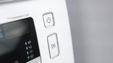 Parmak, çamaşır makinesini çalıştırmak için düğmeye bas. Ev aletleri