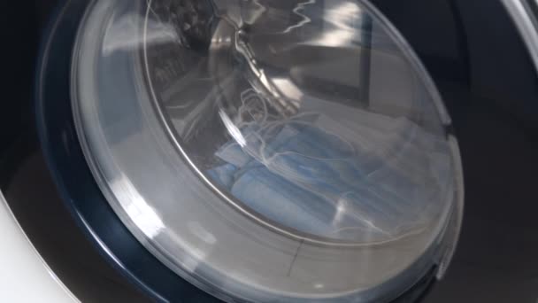 Máquina de lavar lava máscaras médicas sujas. Close up vídeo de fiação tambor máquina de lavar roupa — Vídeo de Stock
