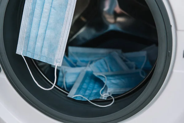 Çamaşır makinesinde tıbbi maskeler. Çamaşır makinesi yükleniyor — Stok fotoğraf