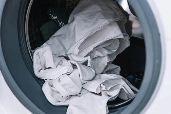 Smutsiga kläder i tvättmaskinen. Tvättmaskin belastning — Stockfoto