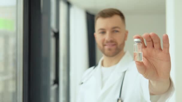 A doctor holds an ampoule with a vaccine in his hand — Vídeo de stock