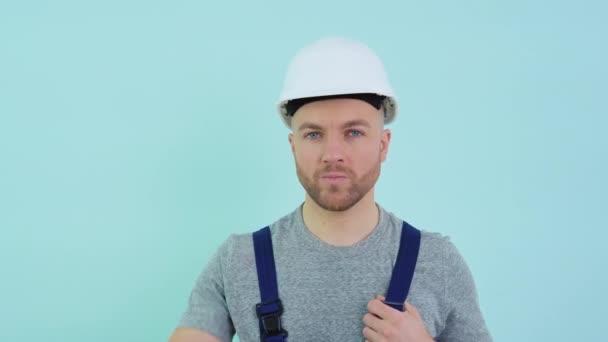 Служащий в комбинезоне надевает шлем — стоковое видео