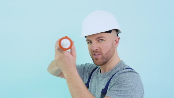 Repairman in overalls holding silicone adhesive — Stock Video