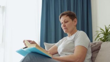 Rahat bir son sınıf öğrencisi olarak kanepede oturup evde kitap okuyorum.