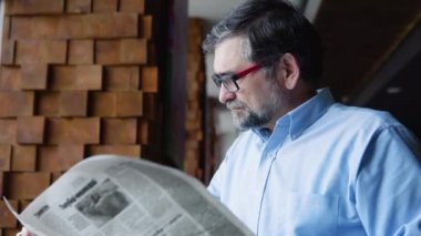 Cafe 'de kitap okuyan yakışıklı, kıdemli adam.