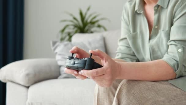 Vista laterale della donna anziana che gioca al videogioco e utilizza il joystick — Video Stock