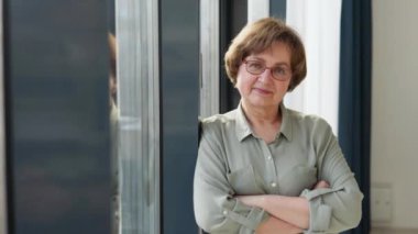 Güzel, son sınıf öğrencisi bir ışık odasında pencerenin yanında duruyor.