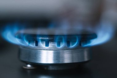 Mutfak ocağı açık. Gaz açık, mavi alev görünüyor.