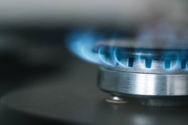 Mutfak ocağı açık. Gaz açık, mavi alev görünüyor.