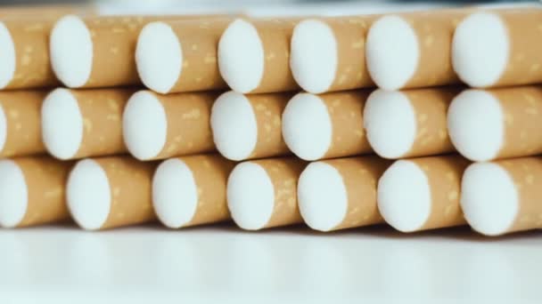 Σωρός τσιγάρων καπνού περιστρέφεται σε λευκό φόντο από κοντά. Κλείσιμο φόντο ή υφή τσιγάρου καπνού — Αρχείο Βίντεο