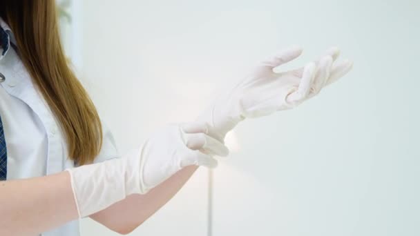 Woman veterinarian puts on medical gloves in vet clinic — Vídeo de stock