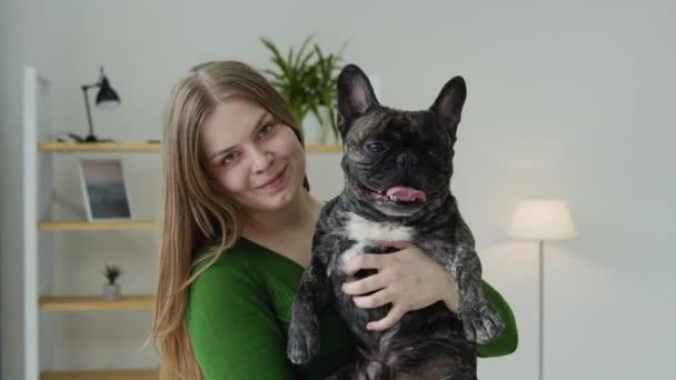 Gelukkig jong vrouw knuffelt haar hond thuis — Stockvideo