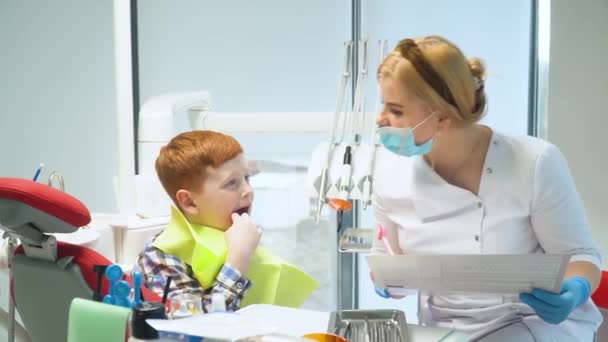 Female dentist and little boy in dental clinic. Pediatric dentistry — Vídeo de Stock