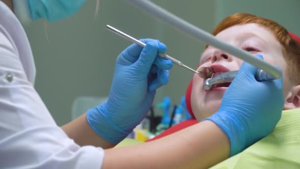 Un niño pequeño que tiene un tratamiento de limpieza dental en la odontología. Odontología pediátrica — Vídeo de stock