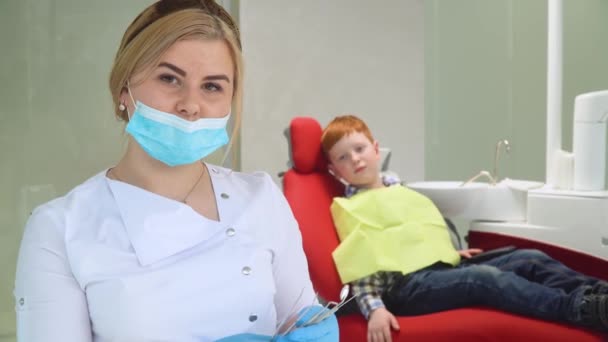 Dentystka i mały chłopiec w klinice dentystycznej. Stomatologia dziecięca — Wideo stockowe