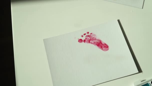 Fingerprints of a small child on white paper — стоковое видео