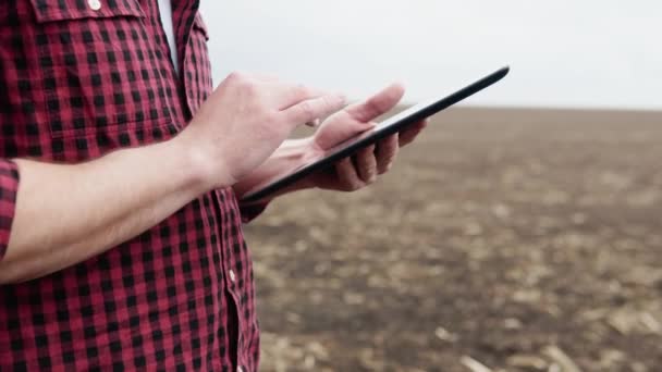 Farmer on a field with a tablet before planting agricultural cultures — Stock video