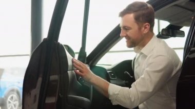 Satın almadan önce aracı inceleyen bir adam. Araba al.