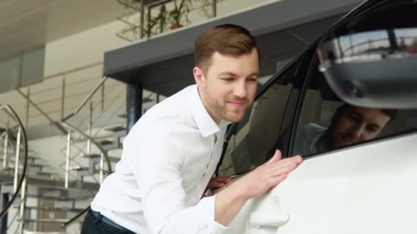 Mężczyzna bada swój nowy samochód. Auto biznes, sprzedaż samochodów, technologie i koncepcja narodów — Wideo stockowe