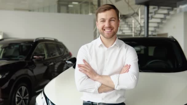 Smiling car dealer in formal uniform posing at favorite work with crossed hands. Confident car dealer providing professional service for customers — Stock video