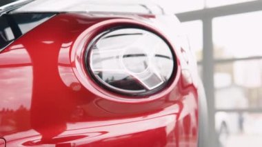 Close up of details of headlights of anonymous prestigious red modern car. Concept of passion for driving cars, car dealerships, luxury cars. Shot in 4K. Head light