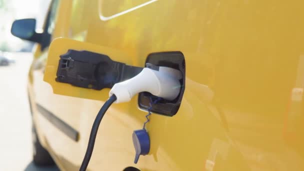 Pengisian mobil listrik. Mobil listrik kuning terisi penuh di stasiun pengisian — Stok Video