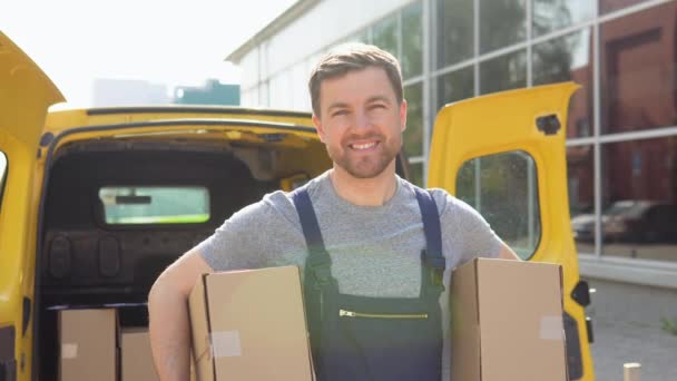 Portrait of a courier holding a two parcels, a yellow car in the background. Delivery of medicines and products — Vídeos de Stock