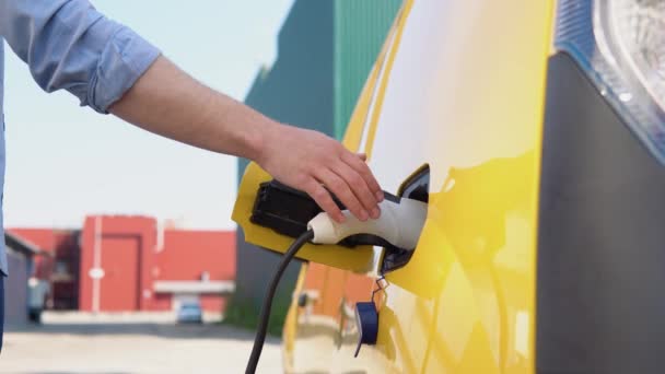 Unrecognizable man unplugs charging cable electric vehicle. Male hand disconnects power connector into EV car — Stock Video