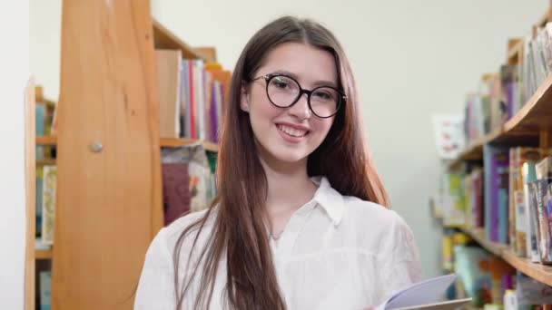 Portrait of a beautiful girl in the university library — Stock video