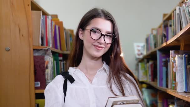 Πορτρέτο ενός όμορφου κοριτσιού στη βιβλιοθήκη του πανεπιστημίου — Αρχείο Βίντεο