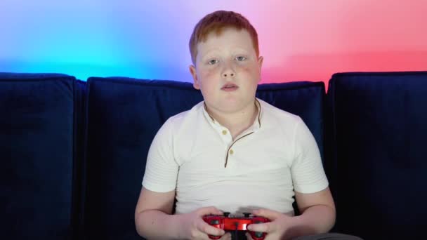 Chlapec-hráč živá hra streaming. Malý hráč hraje hru a dívá se na obrazovku na počítači PC. Koncept digitální technologie a počítačových her. Barva Cyberpunku — Stock video