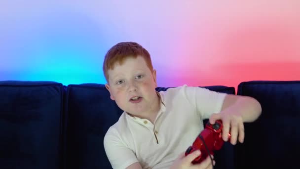 Ένα αγόρι-gamer live streaming παιχνίδι. Μικρό gamer παίζοντας παιχνίδι και κοιτάζοντας την οθόνη στον υπολογιστή του υπολογιστή. Έννοια της ψηφιακής τεχνολογίας και του κυβερνοχώρου. Χρώμα Cyberpunk — Αρχείο Βίντεο