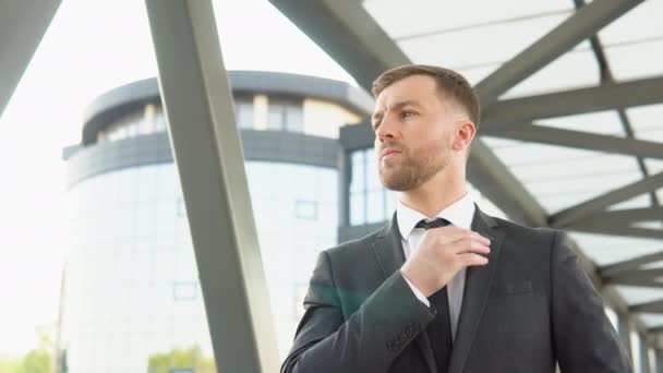 A well dressed happy bearded office corporate male executive standing outside a modern corporate building — Vídeo de Stock