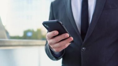 Modern ofis binasının yakınında konuşan bir iş adamı.