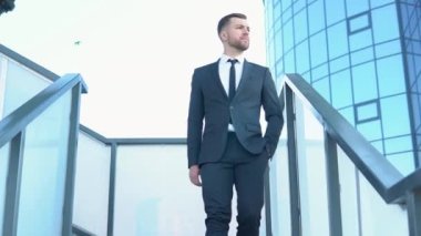 Confident guy in leather shoes and suit being on his way to office building. Businessman in suit being on his way to work. Cityscape background