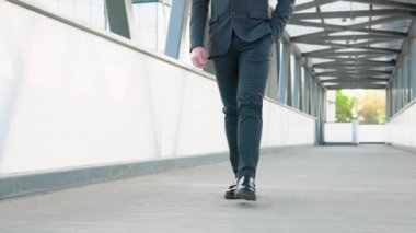 Cinematic close up shot of legs with black leather shoes of anonymous business man is walking in city center street on way to office before to start his work day