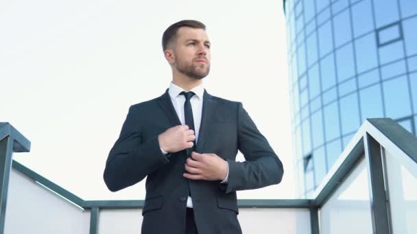 Um bem vestido escritório barbudo feliz executivo corporativo masculino em pé fora de um edifício corporativo moderno e ajuste terno e gravata — Vídeo de Stock