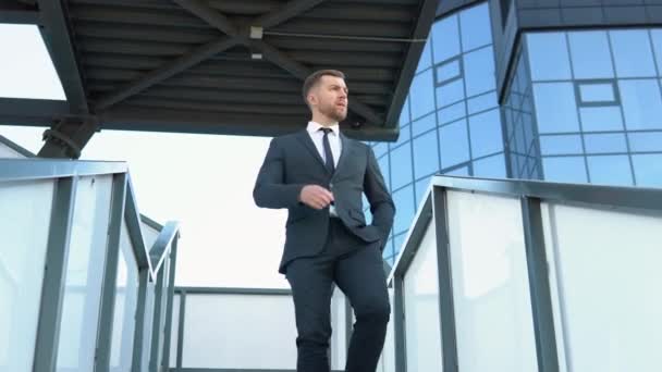 Confident guy in leather shoes and suit being on his way to office building. Cityscape background — Vídeos de Stock