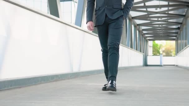 Cinematic close-up shot van benen met zwart lederen schoenen van anonieme zakenman loopt in het centrum van de stad straat op weg naar kantoor voordat om zijn werkdag te beginnen — Stockvideo