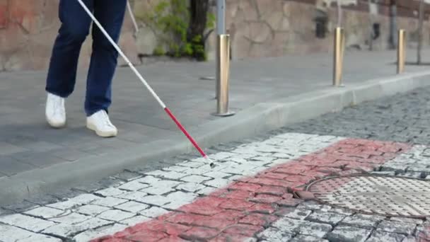 Слепой человек с тростью переходит дорогу. — стоковое видео
