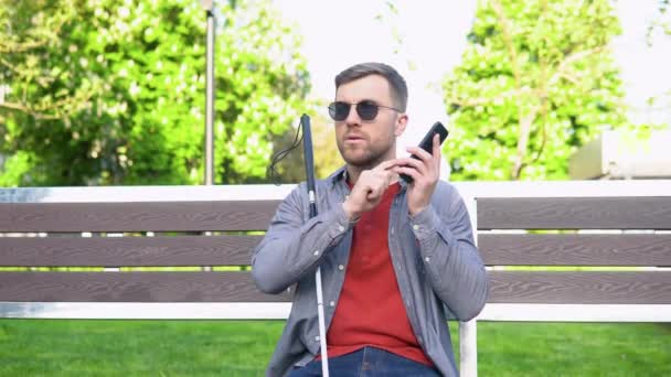 Homem cego com deficiência usando assistente digital e funções de facilidade de acesso no smartphone — Vídeo de Stock